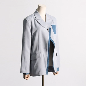 Detail of grey blazer featuring dark blue denim patchwork lapels and refined twill texture