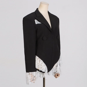 Detail showing white lace patchwork on cuffs and hem of a slim fit black blazer