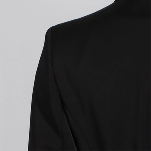 Vista dettagliata della cucitura della spalla e del tessuto pregiato di un blazer nero