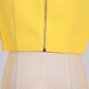 Vue détaillée du crop top jaune vif avec tissu texturé et fermeture éclair argentée au dos