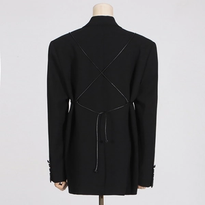 Detail of black blazer back featuring elegant criss-cross lace-up straps and tailored fit