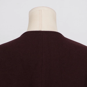 Close-up of dark burgundy wool blend jacket collar and shoulder texture with fine stitching