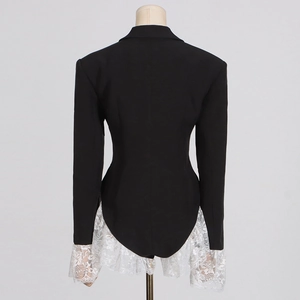 Detail view of the black slim-fit blazer with white lace ruffled hem and sleeves at the back