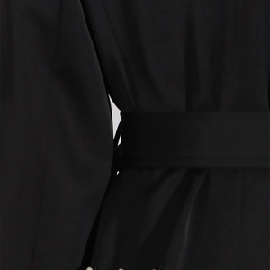 Dettaglio di abito nero satinato con cintura in vita e decorazione di perle sul bordo