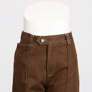 Detail of dark brown casual trousers featuring button closure and vertical seam stitching
