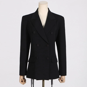 Detail of black double-breasted blazer featuring unique tassel fringe trim at the hemline