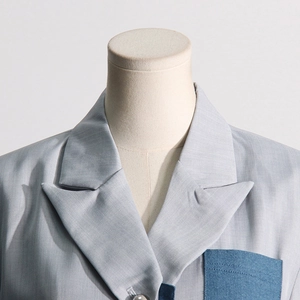 Close-up of peaked lapel suit with contrast navy pocket and pearlescent button