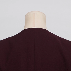 Detail view of the back seam and burgundy woven fabric texture on this blazer