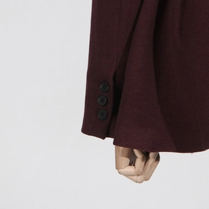 Close-up of coat sleeve with wool texture and three black buttons on a wood hand prop