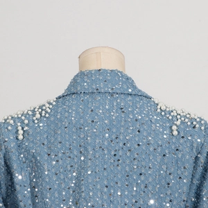 Close-up of light blue denim collar with shimmering sequins and pearl embellishments