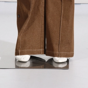 Detail of brown wide-leg pants with white contrast stitching and side metal buttons