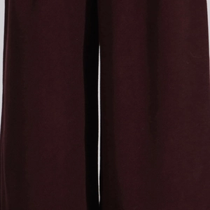 Close-up of deep burgundy wide-leg trousers showing premium twill fabric texture
