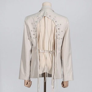 Detailed back view of beige blazer featuring cut-out design and hanging fringe tassels