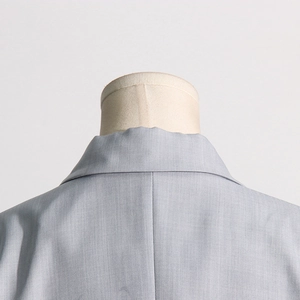 Close-up of the elegant notched lapel and twill fabric texture on a light blue blazer