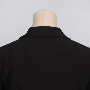 Detail of tailored black blazer collar and shoulder stitching on a mannequin