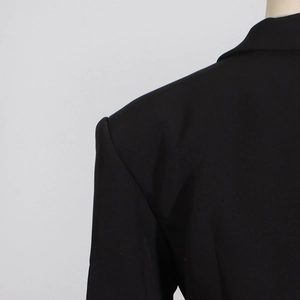 Close-up detail of structured shoulder and back stitching on this black lace blazer bodysuit