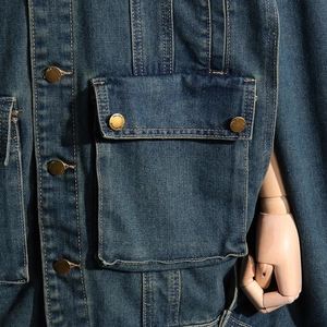 Detail of dark blue denim jacket with vintage brass button and contrast stitching