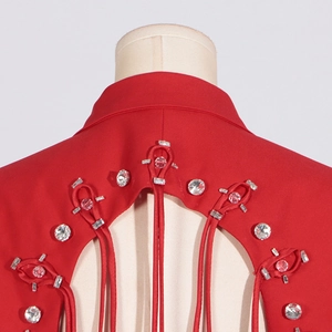 Macro detail of red suit jacket back with rhinestone fringe and cutout design