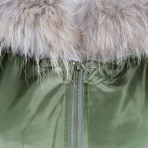 Close-up of olive green parka jacket with fluffy faux fur collar and vintage metal zipper