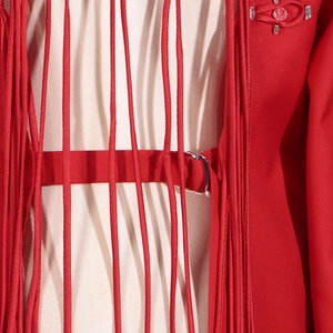 Close-up of red fringe jacket with metallic D-ring buckle and rhinestone details