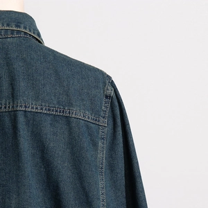 Detailed view of dark blue denim jacket shoulder with reinforced double stitching