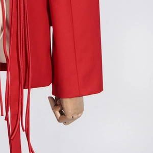 Detailed close-up of vibrant red blazer with elegant long tassels and premium fabric texture