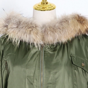 Close-up of fluffy faux fur collar and windproof fabric on army green parka jacket