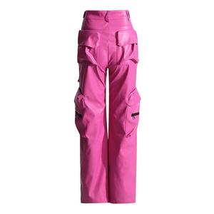 Dettaglio dei pantaloni cargo in pelle PU rosa con tasche multiple e cerniere nere a contrasto
