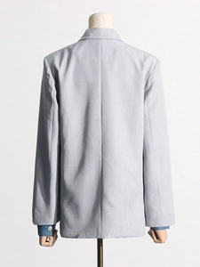 Light blue business casual blazer with denim patchwork sleeves and metal buttons