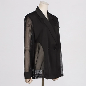 Détail d'un blazer noir élégant avec empiècements en tulle et boutons à double boutonnage