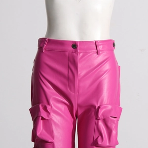 Dettaglio dei pantaloni cargo fucsia in pelle sintetica a vita alta con bottoni metallici