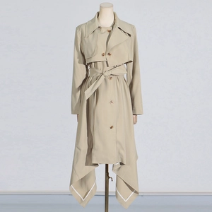 Detail of khaki trench coat with asymmetric pointed hem and white contrast stitching