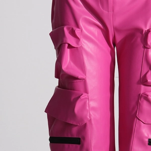 Dettaglio dei pantaloni cargo in ecopelle rosa acceso con vita alta e ampie tasche