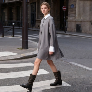 Detail of grey shirt dress with white contrast collar and cuffs in urban setting