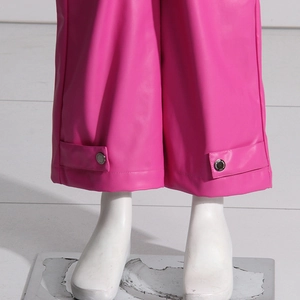 Dettaglio fondo pantalone in pelle PU rosa con cinturino decorativo e bottone metallico