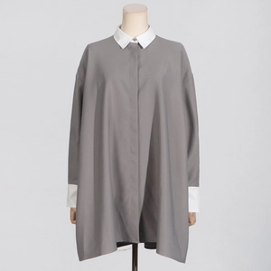 Detail view of contrast collar and hidden placket on a loose grey and white casual shirt