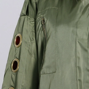Detail of olive green jacket sleeve featuring golden eyelets and a vertical zipper pocket