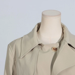 Macro detail of beige trench coat collar with elegant marble button and premium stitching