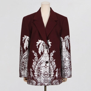 Gros plan détaillé du blazer bordeaux avec motifs paisley complexes en feuille d'argent