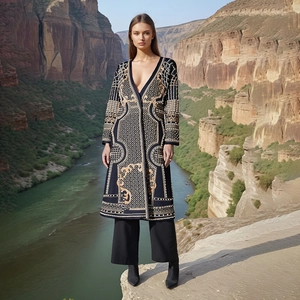Détail d'un long trench-coat ethnique avec broderies dorées et décolleté en V profond
