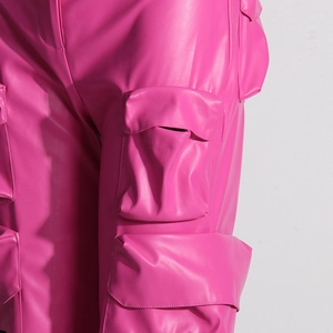 Dettaglio dei pantaloni cargo in pelle PU rosa brillante con tasche laterali