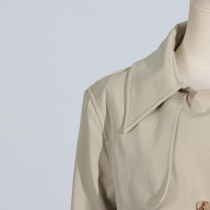 Close-up of beige trench coat lapel featuring brown amber texture button details