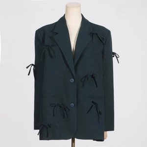 Détails du blazer vert foncé avec nœuds faits main et tissu à texture mate