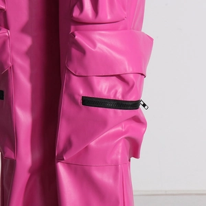 Dettaglio macro dei pantaloni cargo in ecopelle rosa con tasca 3D e cerniera in metallo nero