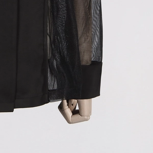 Gros plan détaillé du blazer noir élégant avec empiècements en résille transparente aux manches
