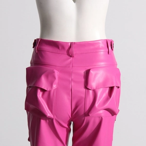 Dettaglio dei pantaloni cargo in ecopelle rosa con vita alta e ampie tasche posteriori
