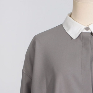 Detailed view of women's gray casual shirt with contrast white collar and shoulder stitching
