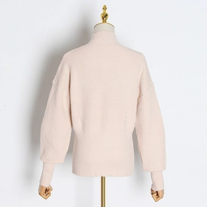 Detail view of pink knit sweater featuring vertical ribbing and wide ribbed hem finish