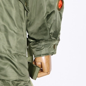 Detail of army green parka jacket with metallic eyelets and snap button cuffs