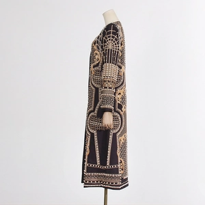 Détail d'un manteau de luxe noir avec tissage de perles blanches et broderies dorées